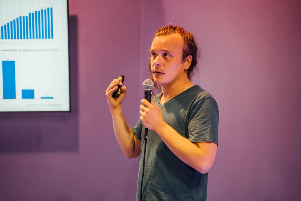Speaker erläutert bei einem Vortrag eine Datenvisualisierung mit Balkendiagrammen