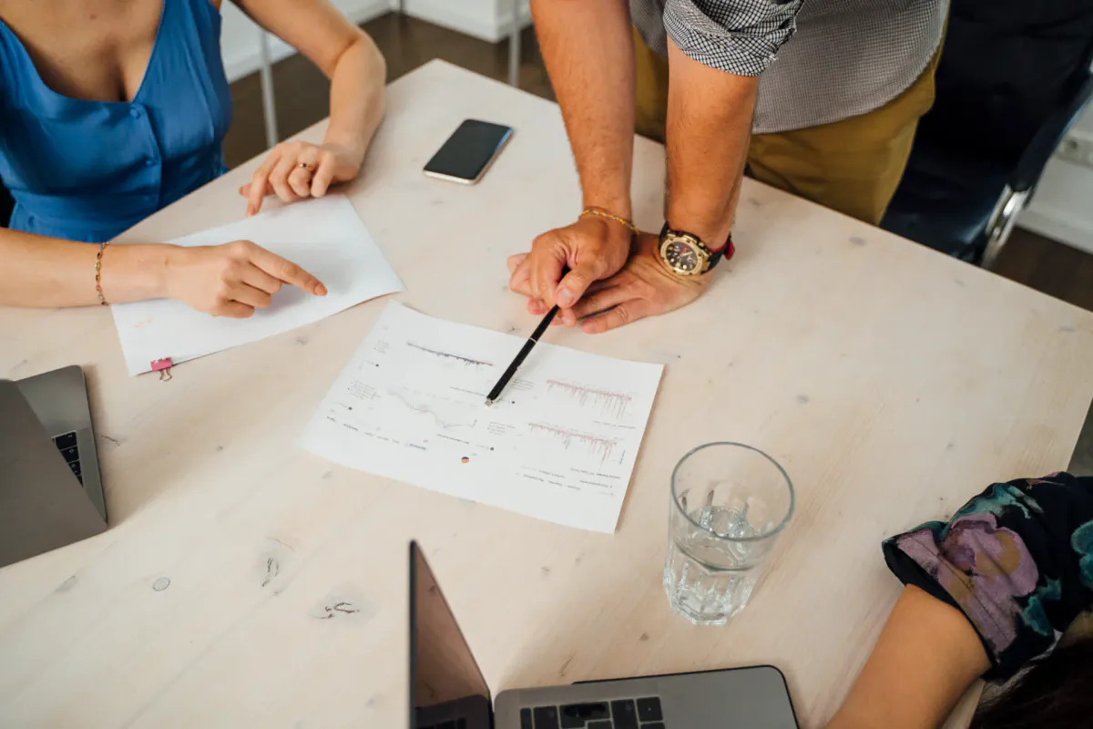 Team analysiert ausgedruckte Diagramme und Suchdaten an einem Arbeitstisch